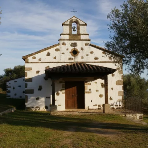 Ermita blanca entre olivos con campanario sencillo