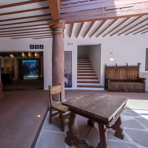 Sala histórica con mesa de madera y columnas de piedra
