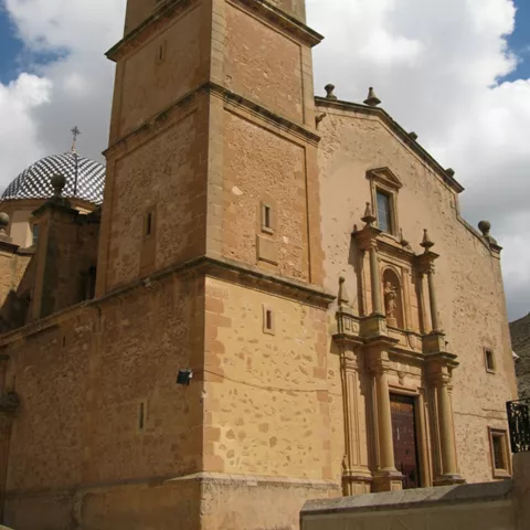 Iglesia de piedra con torre campanario y fachada monumental