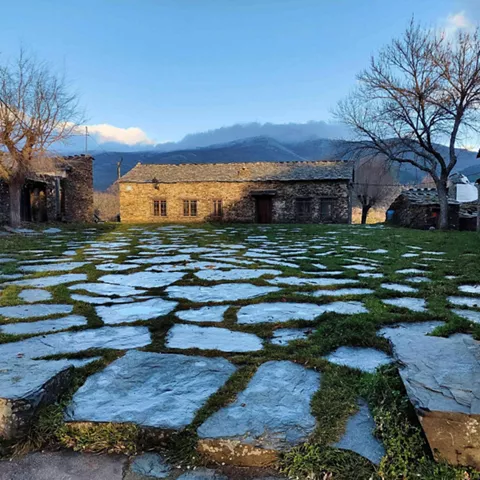 Plaza empedrada con casas tradicionales de piedra.