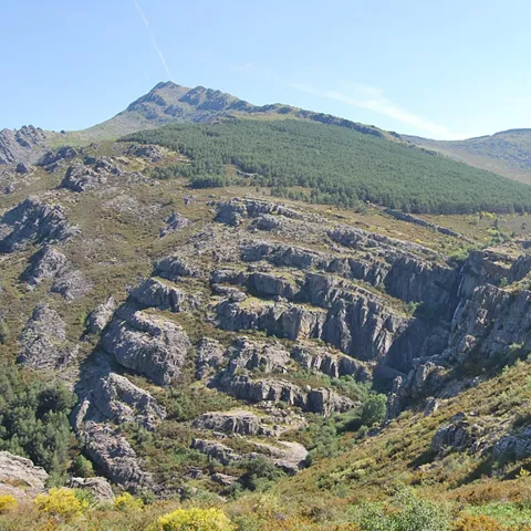 Barranco y cascada en paisaje de montaña.