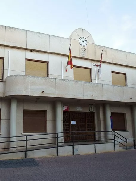 Ayuntamiento de Pozohondo con fachada moderna, reloj central y banderas oficiales.