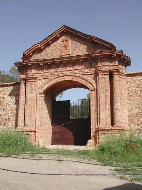 Entrada monumental de ladrillo en entorno rural