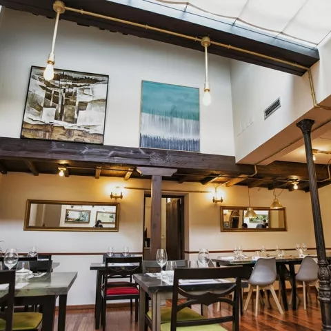 Gran salón clásico con vidriera en el techo, lámparas de araña y mobiliario refinado.