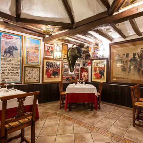 Comedor rústico con carteles y decoración taurina