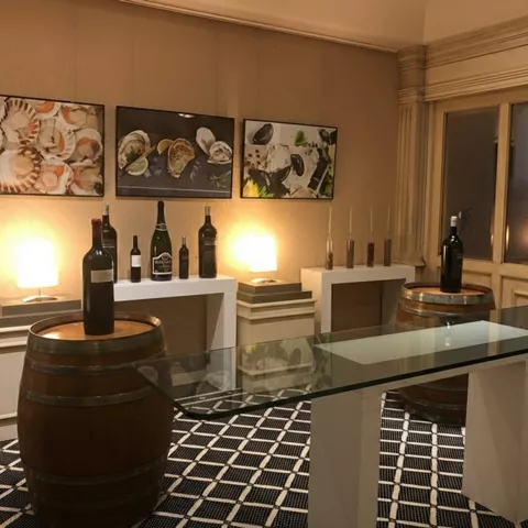 Rincón interior con barriles, botellas de vino y cuadros gastronómicos.