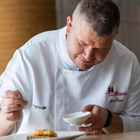 Chef añadiendo salsa con cuchara