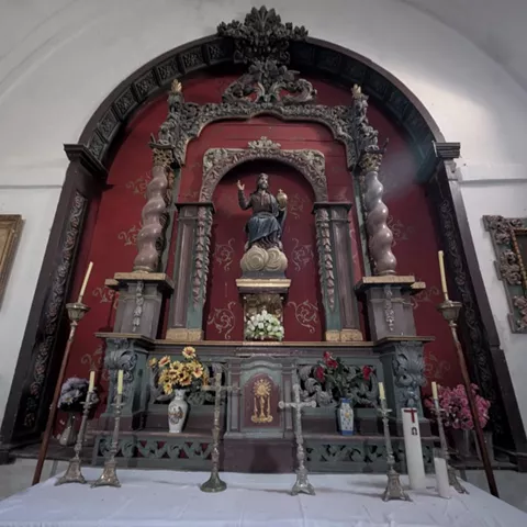Retablo barroco con columnas salomónicas y figura central.