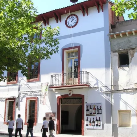 Fachada de edificio histórico con reloj y personas caminando frente a la entrada.