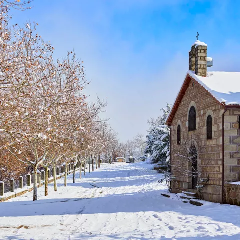 Camino nevado junto a una pequeña construcción de piedra.