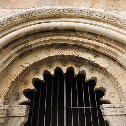 Detalle de portada románica con arco decorado.
