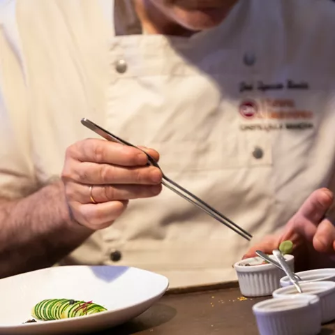 Chef decorando plato con pinzas