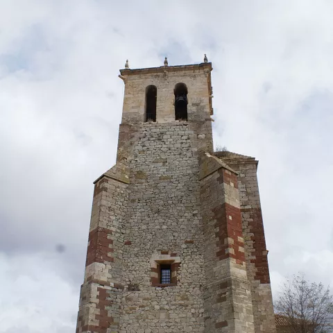 Torre de iglesia de piedra vista desde abajo contra el cielo.
