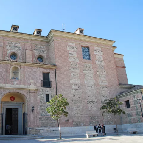 Fachada principal de edificio religioso con portada monumental y ventanas circulares.