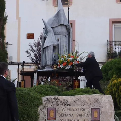Ofrenda floral a una escultura conmemorativa en una plaza