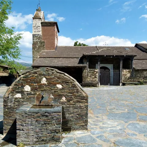 Plaza empedrada con iglesia rural.