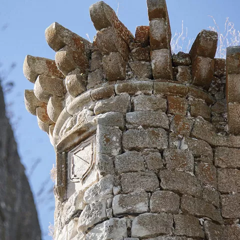 Detalle de almenas y escudo tallado en piedra.