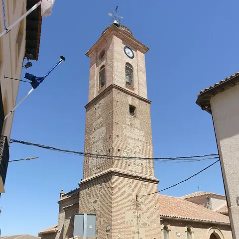 Torre campanario de iglesia vista desde una calle