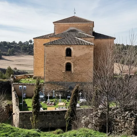 Vista trasera de la iglesia con entorno rural y cementerio