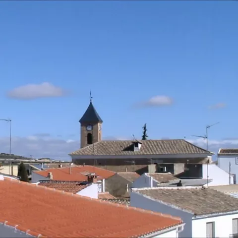 Una toma de nivel superior que muestra los tejados de un pueblo con el campanario de una iglesia a lo lejos.