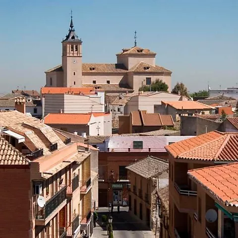 Calle recta con edificios de teja y templo al fondo
