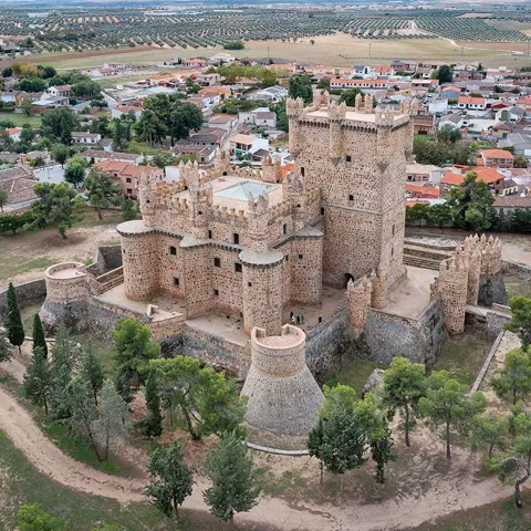 Vista aérea de fortaleza medieval junto a un núcleo urbano