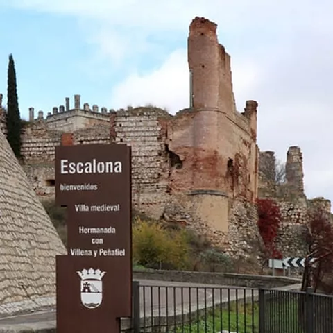 Panel informativo junto a ruinas de fortaleza medieval de piedra