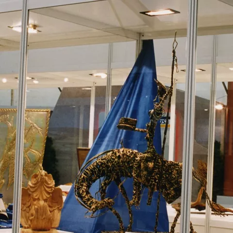 Vitrina con piezas de artesanía y figura metálica