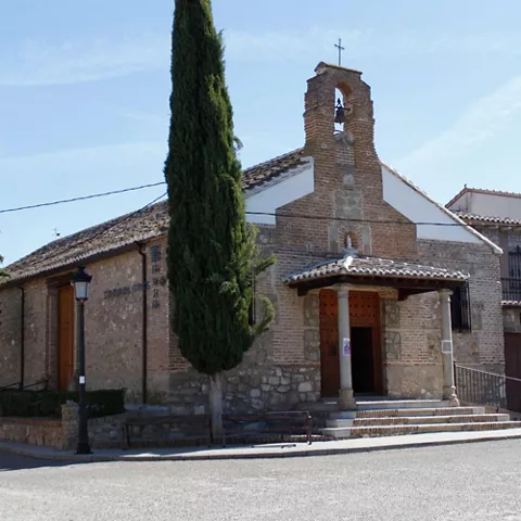 Ermita de piedra y ladrillo con espadaña y cipreses