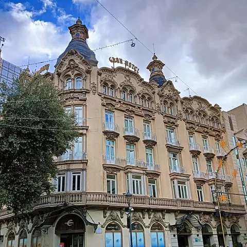 Edificio histórico de estilo modernista con balcones y decoración elaborada en fachada.