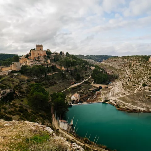 Vista panorámica de un valle con río curvo, colinas y construcciones históricas