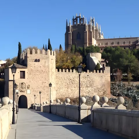 Puerta fortificada al final de un puente de piedra