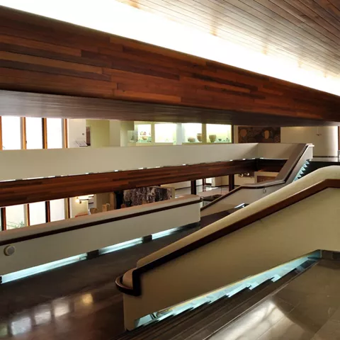 Interior moderno con rampas, pasillos amplios y revestimientos de madera.