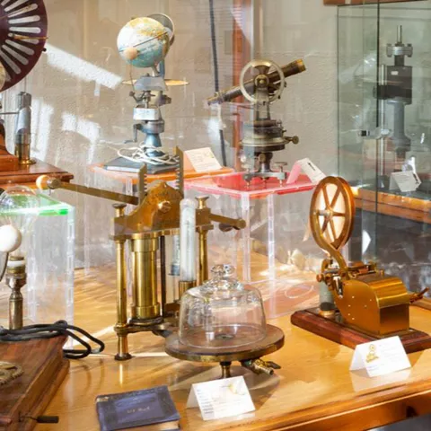 Vitrina con instrumentos científicos antiguos, globos y aparatos mecánicos.
