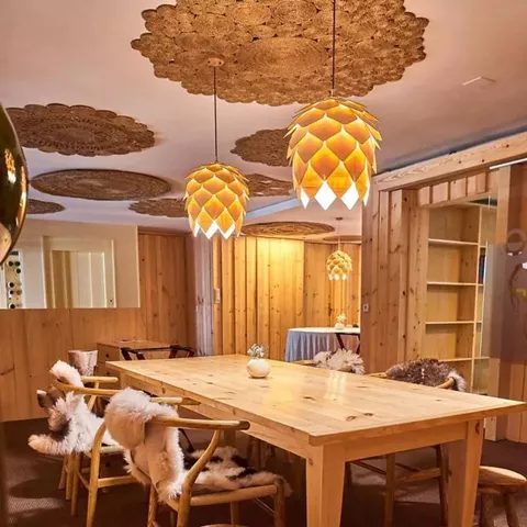 Sala interior con mesa larga de madera y decoración cálida.