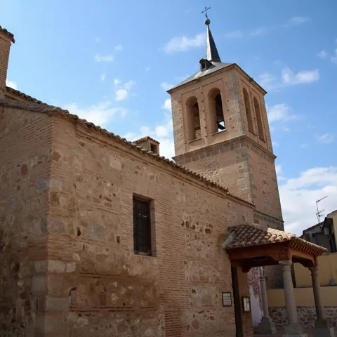 Iglesia de piedra con torre y pórtico de entrada