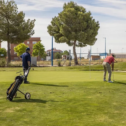 Jugadores practicando putt en el green