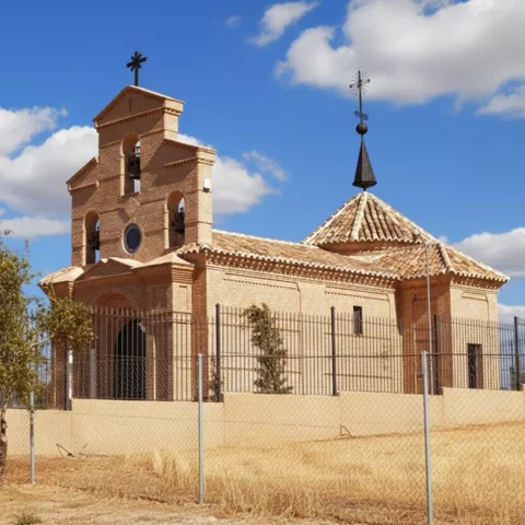 Ermita de ladrillo en entorno rural vallado