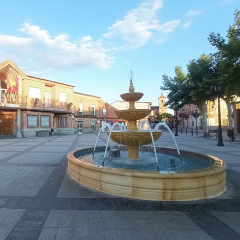 Plaza urbana con fuente central y edificios tradicionales