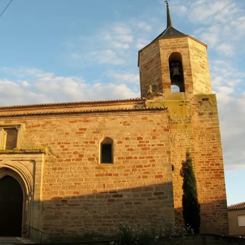 Fachada de iglesia de piedra con torre campanario