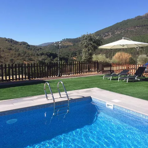 Piscina exterior con tumbonas frente a la sierra