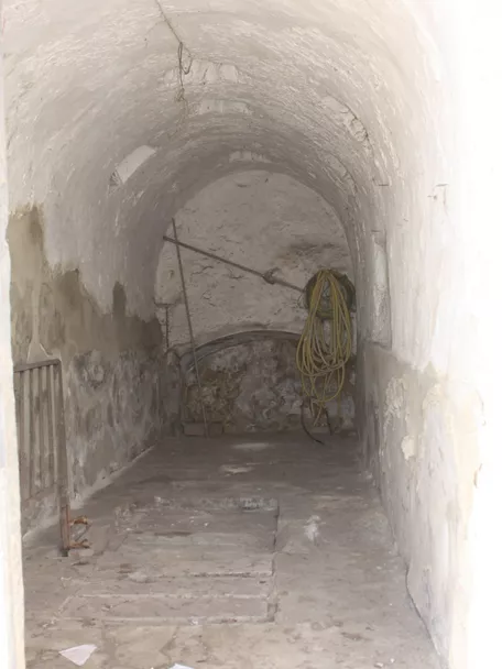 Sala estrecha con bóveda de cañón y muros encalados.