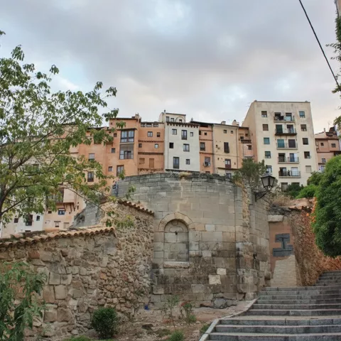 Escalinata y muro antiguo bajo casas elevadas