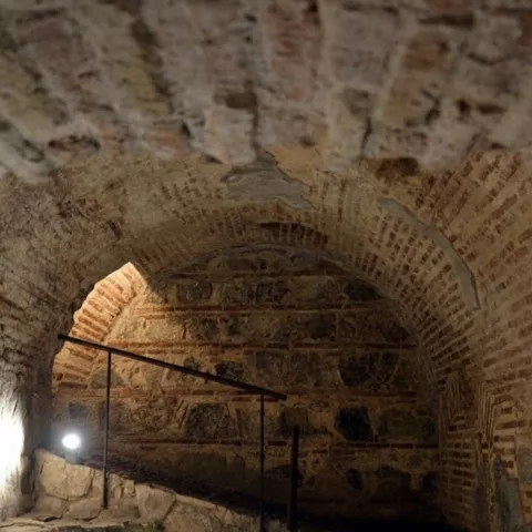 Galería abovedada de ladrillo con rampa y luz puntual.