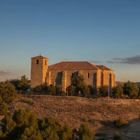 Iglesia sobre loma al atardecer.