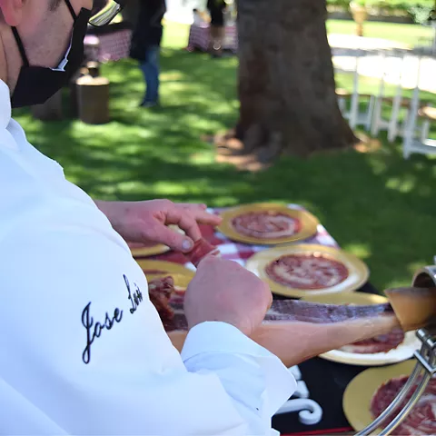 Cortador sirviendo lonchas de embutido en platos