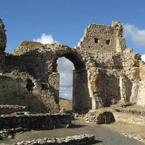 Arco de acceso y ruinas de fortaleza medieval de piedra