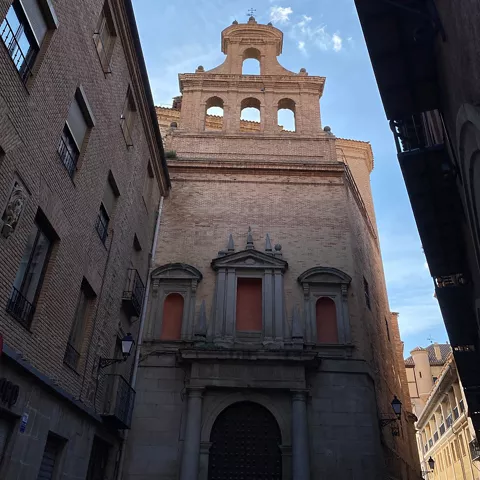 Torre de iglesia vista desde calle estrecha