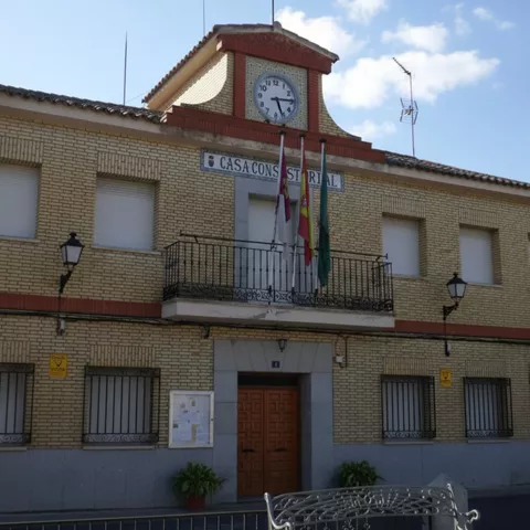 Edificio municipal de ladrillo con reloj y balcones