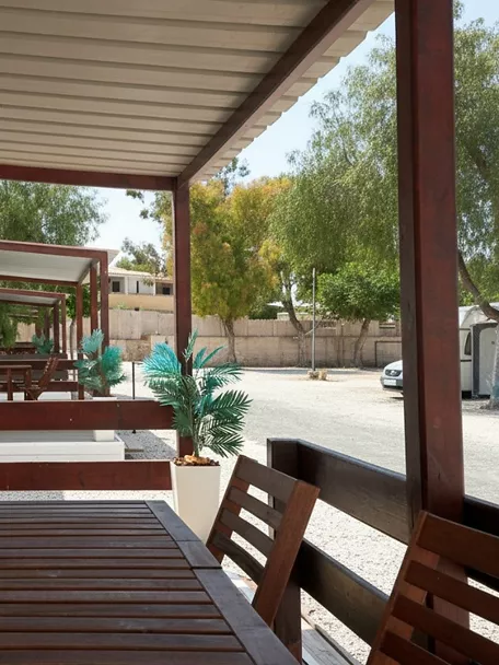 Porche de bungalow con mesa de madera y sillas